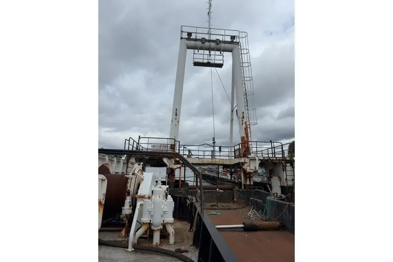 Slide: The Image of 1976 Halter Custom Built Mid-Water Trawler deck with fishing equipment under cloudy sky. - 15
