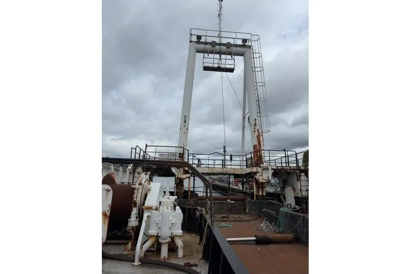 Slide: The Image of 1976 Halter Custom Built Mid-Water Trawler deck with fishing equipment under cloudy sky. - 6