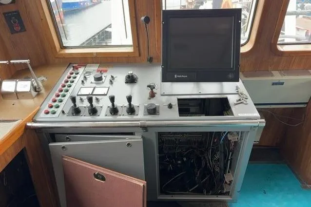 Slide: The Image of Control panel of a 1976 Halter Custom Built Mid-Water Trawler, featuring various switches and a monitor. - 7