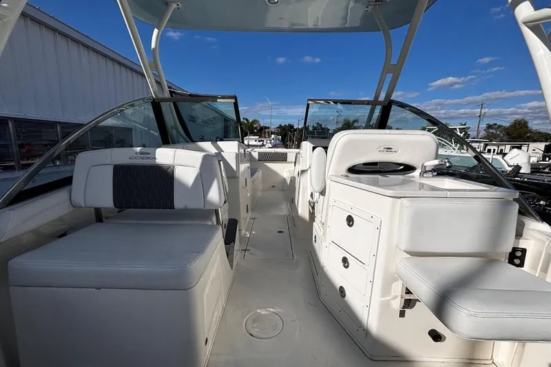 Slide: The Image of 2025 Cobia 240 Dual Console boat interior with seating and storage under a clear blue sky. - 11