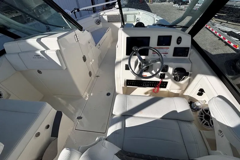 Slide: The Image of 2025 Cobia 240 Dual Console boat interior with steering wheel and seating. - 12