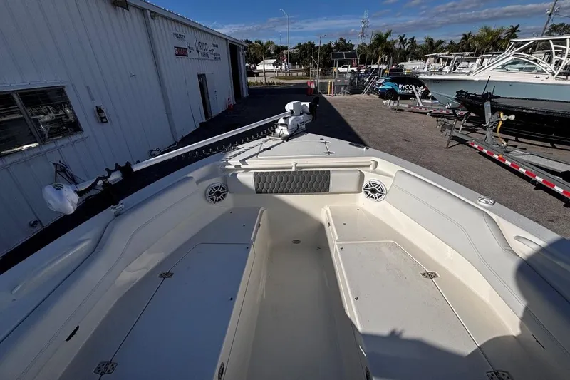 Slide: The Image of 2025 Cobia 240 Dual Console boat interior at a marina, showcasing spacious seating and storage. - 14