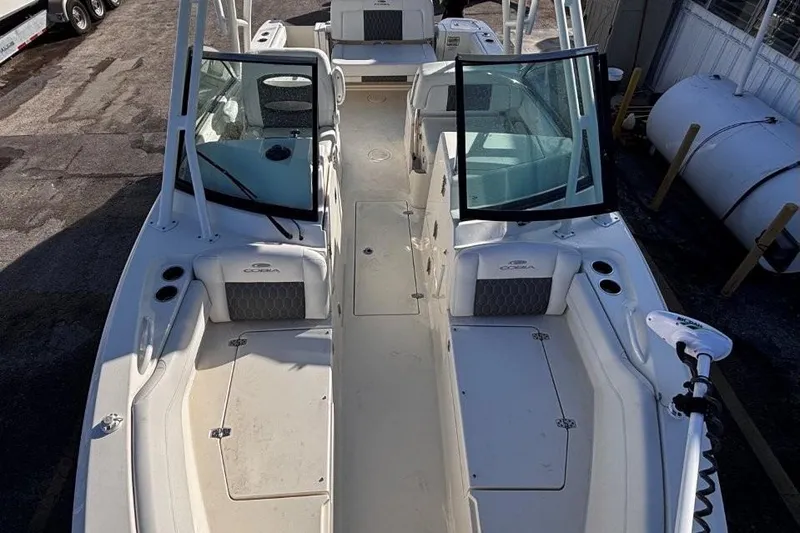 Slide: The Image of 2025 Cobia 240 Dual Console boat with open deck and seating, docked outdoors. - 15