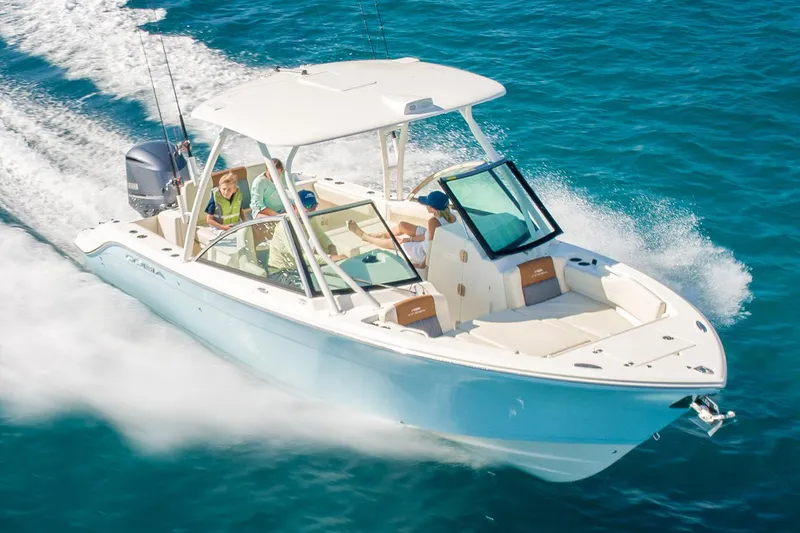 Slide: The Image of Manufacturer Provided Image: 2025 Cobia 240 Dual Console boat cruising on clear blue water. - 18