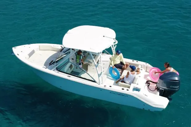 Slide: The Image of Manufacturer Provided Image: 2025 Cobia 240 Dual Console boat on clear blue water with passengers. - 19