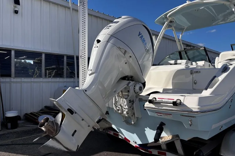 Slide: The Image of 2025 Cobia 240 Dual Console boat with Yamaha outboard motor, docked outdoors. - 6