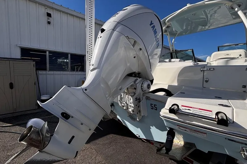 Slide: The Image of 2025 Cobia 240 Dual Console boat with Yamaha outboard motor, docked near a building. - 7