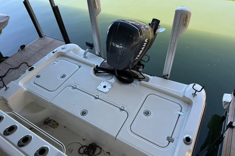 Slide: The Image of 2003 Triton 220 LTS boat with Yamaha motor docked on calm water. - 8