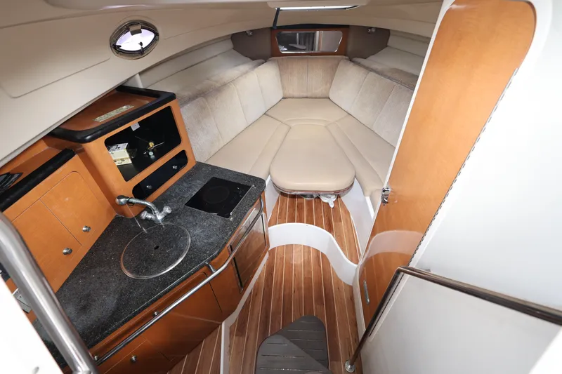 Slide: The Image of 2012 Robalo R305 Walkaround cabin interior with kitchenette and seating area. - 15