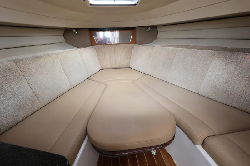 Slide: The Image of 2012 Robalo R305 Walkaround cabin interior with beige seating and wood flooring. - 16