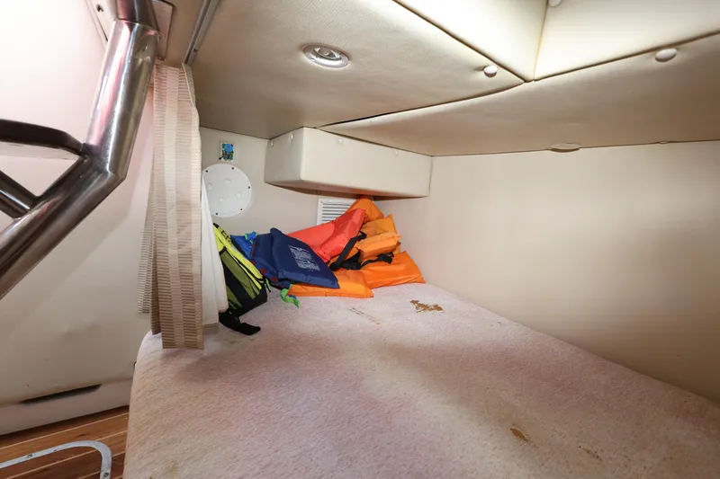 Slide: The Image of 2012 Robalo R305 Walkaround cabin interior with life jackets and storage space. - 19