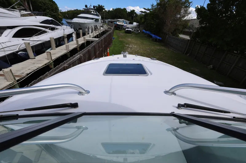 Slide: The Image of 2012 Robalo R305 Walkaround boat docked, view from the bow with surrounding yachts. - 22