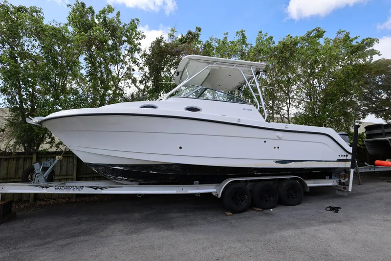 Slide: The Image of 2012 Robalo R305 Walkaround boat on trailer, parked outdoors. - 26