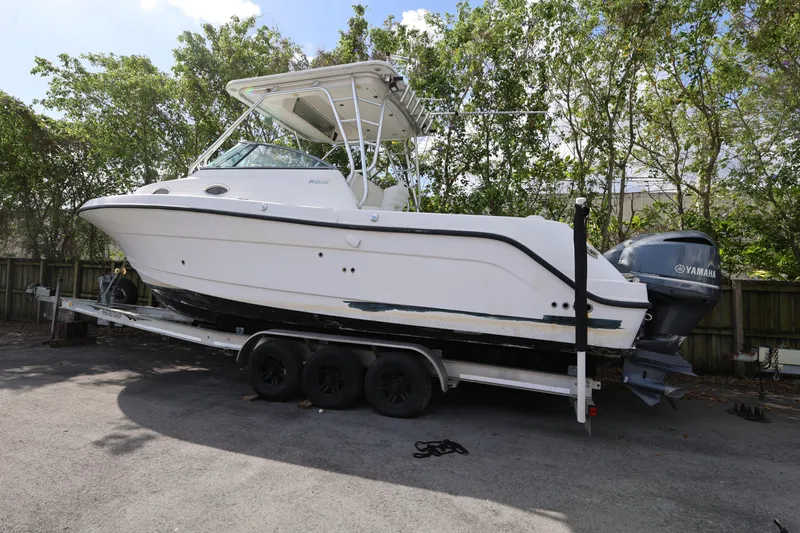 Slide: The Image of 2012 Robalo R305 Walkaround boat on trailer with Yamaha engine, parked outdoors. - 27