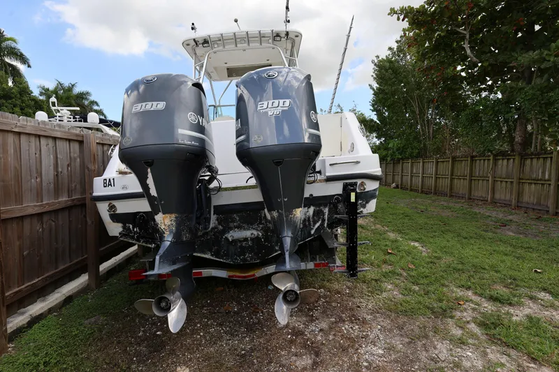 Slide: The Image of 2012 Robalo R305 Walkaround boat with twin Yamaha 300 engines, parked on grass. - 5