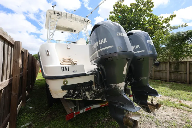 Slide: The Image of 2012 Robalo R305 Walkaround boat with dual Yamaha engines, parked outdoors. - 6