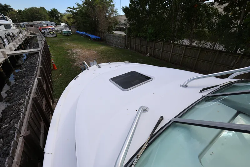 Slide: The Image of 2012 Robalo R305 Walkaround boat docked near a wooden fence and grassy area. - 7
