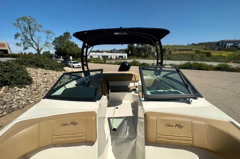 Slide: The Image of 2023 Sea Ray SPX 190 Outboard boat interior with tan seating and open windshield. - 10