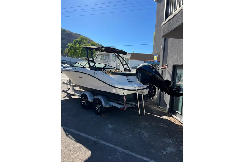 Slide: The Image of 2023 Sea Ray SPX 190 Outboard boat on trailer, parked outdoors. - 2