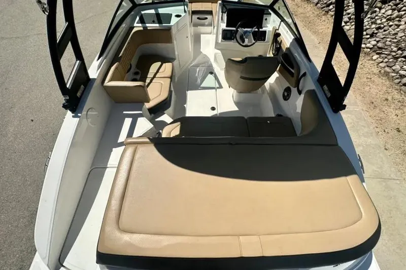 Slide: The Image of 2023 Sea Ray SPX 190 Outboard boat interior with tan seating and modern dashboard. - 6