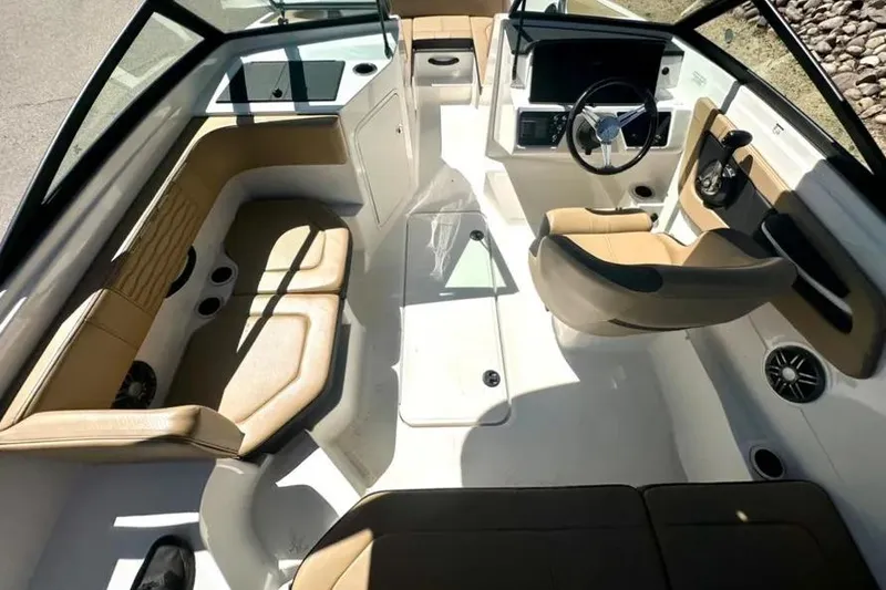 Slide: The Image of 2023 Sea Ray SPX 190 Outboard interior with tan seating and modern dashboard. - 9
