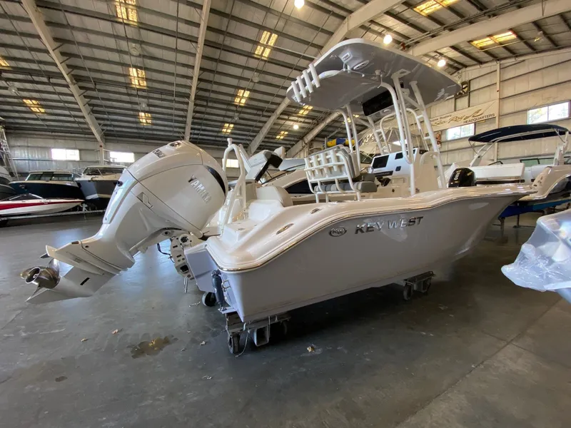 Slide: The Image of 2026 Key West 219 FS boat in showroom, featuring Yamaha outboard motor. - 2