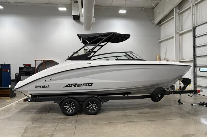 The Image of 2025 Yamaha AR250 boat in a showroom, sleek design, on a trailer. - 1