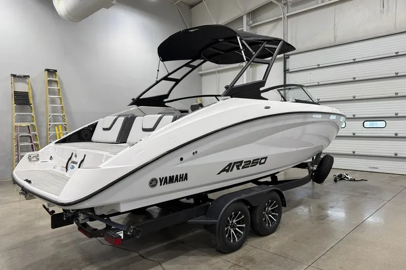 Slide: The Image of 2025 Yamaha AR250 boat on trailer in a garage setting. - 3