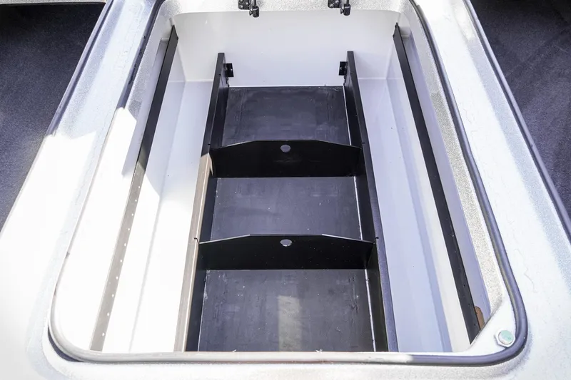 Slide: The Image of 2024 Triton 20XP boat storage compartment, open and empty, with dividers. - 25