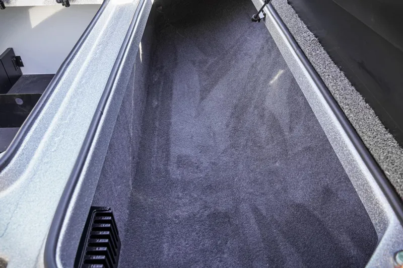 Slide: The Image of Interior storage compartment of 2024 Triton 20XP boat, featuring carpeted lining. - 26