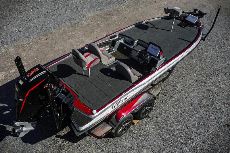 Slide: The Image of 2024 Triton 20XP boat with dual seats, advanced controls, and sleek design on gravel surface. - 3