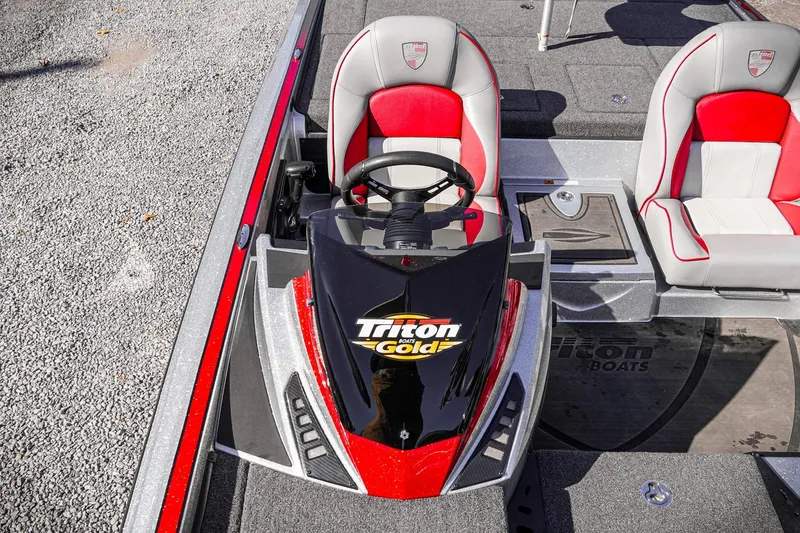 Slide: The Image of 2024 Triton 20XP boat interior with red and gray seats, steering console, and Triton Gold logo. - 33