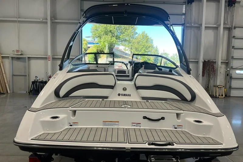 Slide: The Image of 2025 Yamaha Boats AR195 in a showroom, showcasing sleek design and spacious seating. - 4