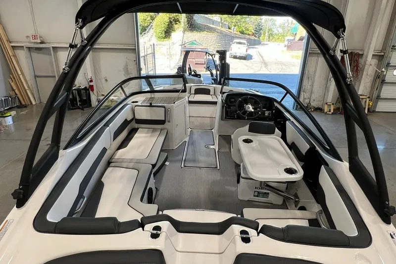 Slide: The Image of 2025 Yamaha Boats AR195 interior with sleek seating and modern dashboard in a showroom. - 7