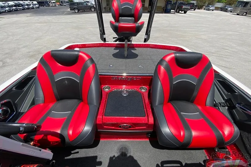 Slide: The Image of 2020 Ranger Z520L boat interior with red and black seats, parked outdoors. - 102