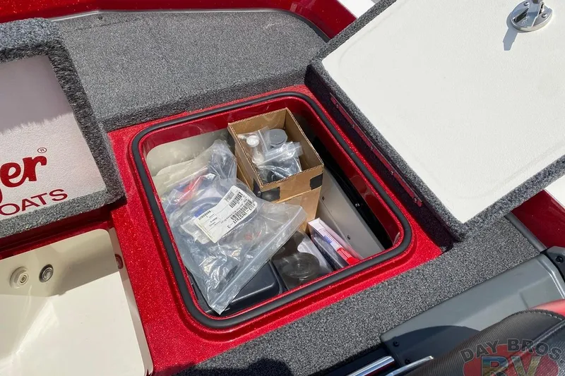 Slide: The Image of Open storage compartment on 2020 Ranger Z520L boat with various items inside. - 108