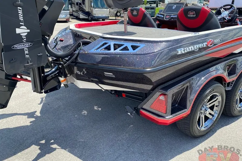 Slide: The Image of 2020 Ranger Z520L boat with Power-Pole, sleek design, and red accents in a parking lot. - 46
