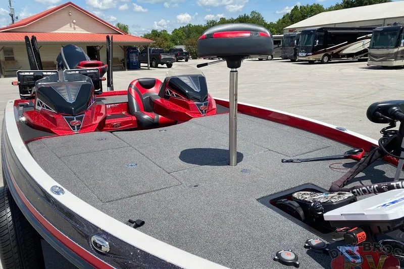Slide: The Image of 2020 Ranger Z520L boat with red accents, parked near RVs under a clear sky. - 59
