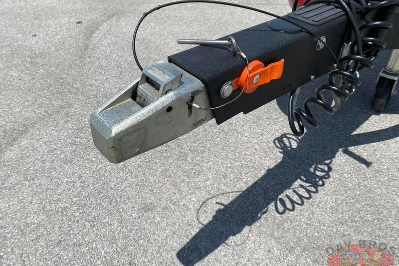 Slide: The Image of Trailer hitch of 2020 Ranger Z520L boat on pavement, featuring safety cables and lock mechanism. - 64