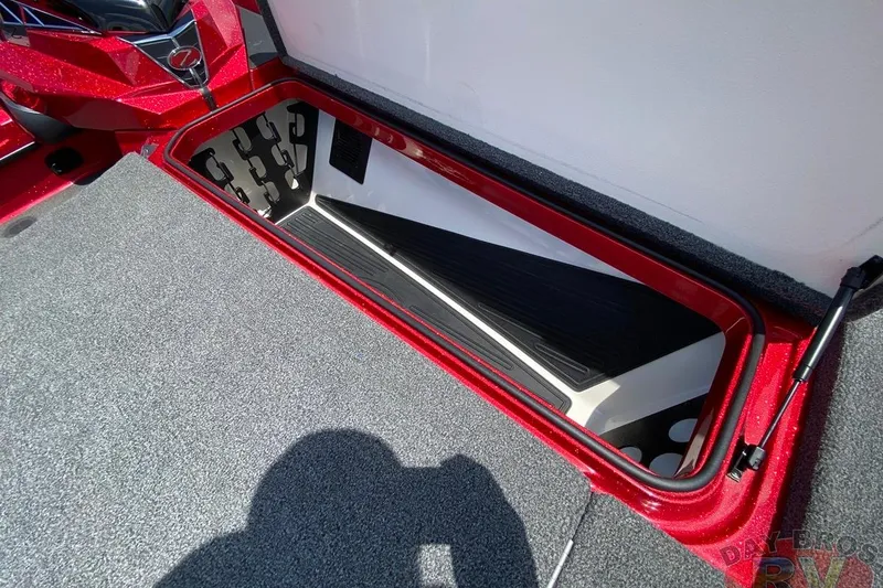 Slide: The Image of 2020 Ranger Z520L boat storage compartment with red trim and carpeted interior. - 80