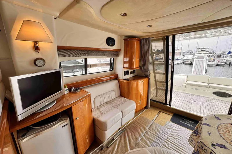 Slide: The Image of Luxurious Cranchi yacht interior with cozy seating, TV, and marina view through large windows. - 10