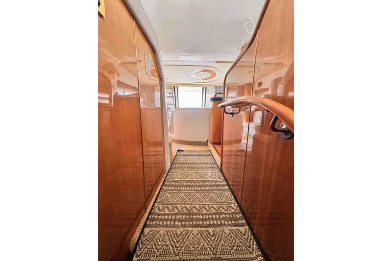 Slide: The Image of Cranchi yacht interior hallway with wooden cabinets and patterned carpet. - 15