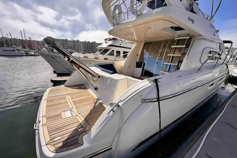 Slide: The Image of 2003 Cranchi Atlantique 50 yacht docked at marina, showcasing sleek design and spacious deck. - 4