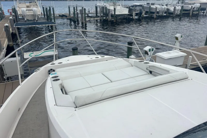 Slide: The Image of 2024 Regal 36 XO yacht with white sunbed, docked at marina. - 10