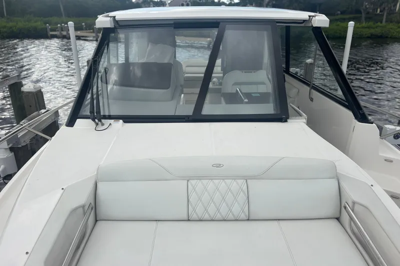 Slide: The Image of 2024 Regal 36 XO boat with sleek design, docked by the water. - 13