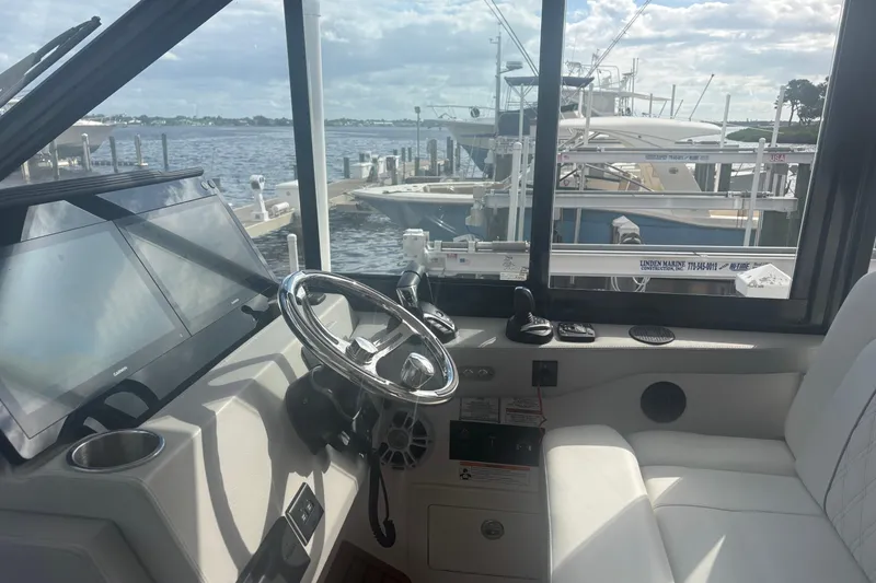 Slide: The Image of 2024 Regal 36 XO boat interior with steering wheel and navigation screens. - 16