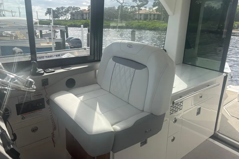 Slide: The Image of 2024 Regal 36 XO boat interior with luxurious white seating and modern helm station. - 20