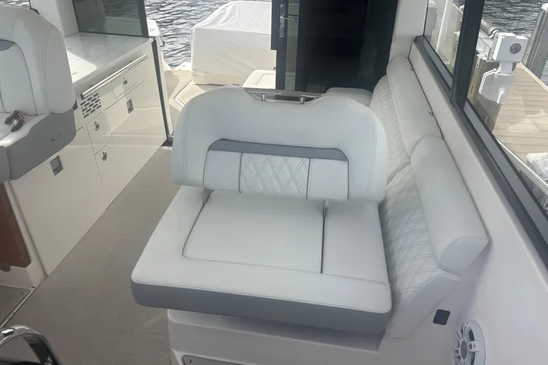 Slide: The Image of 2024 Regal 36 XO boat interior with white cushioned seating and modern design. - 22