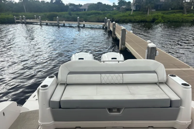 Slide: The Image of 2024 Regal 36 XO boat with rear seating, docked by a wooden pier. - 23
