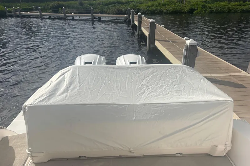 Slide: The Image of 2024 Regal 36 XO boat with covered outboard engines at dockside. - 24